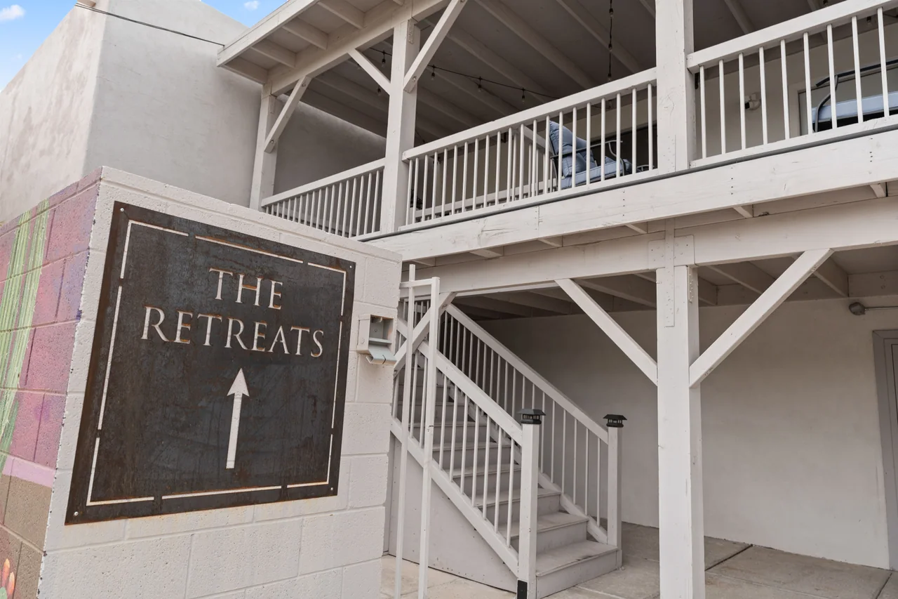 The Retreats sign beside the outdoor stairs leading to the second-floor studios
